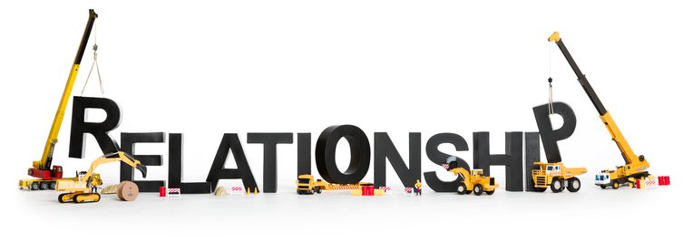 Developing relationship concept: Construction machines building up with letters the word relationship, isolated on white background.
